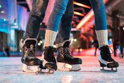 Skates on the ice with coloured lights in the background