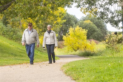 Two older people walking along a path